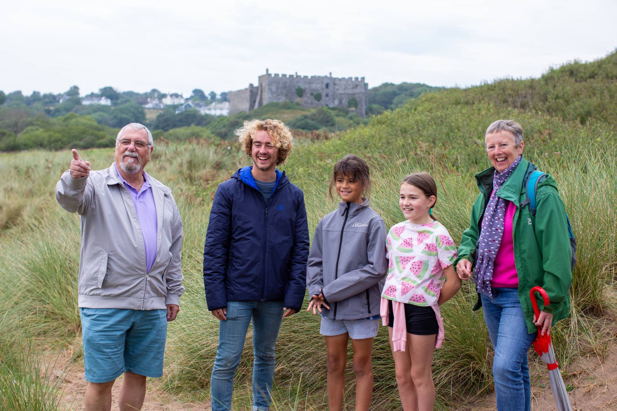 A smiling family standing in front of a castle