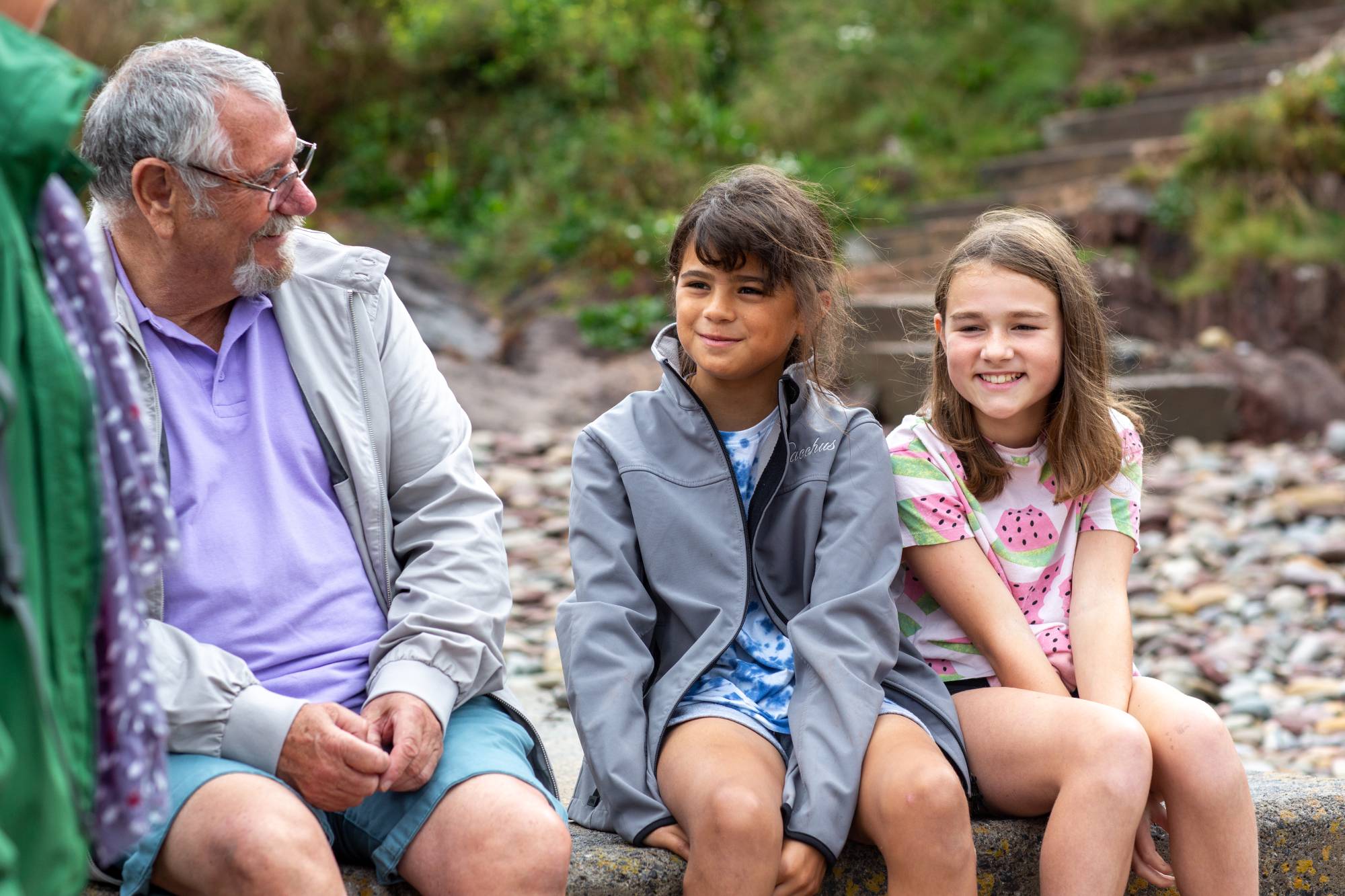 A dad and his two daughters sat on the beach
