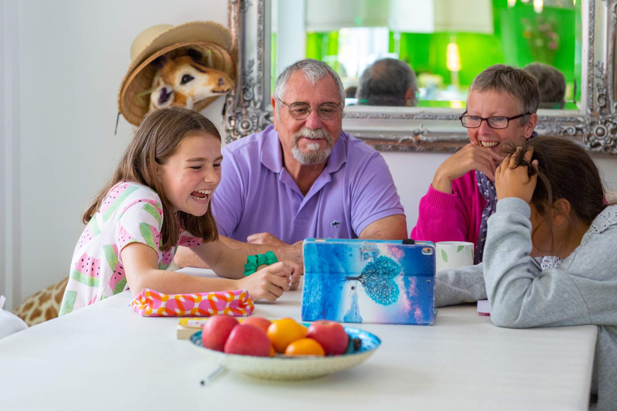 A family looking at their iPad and laughing