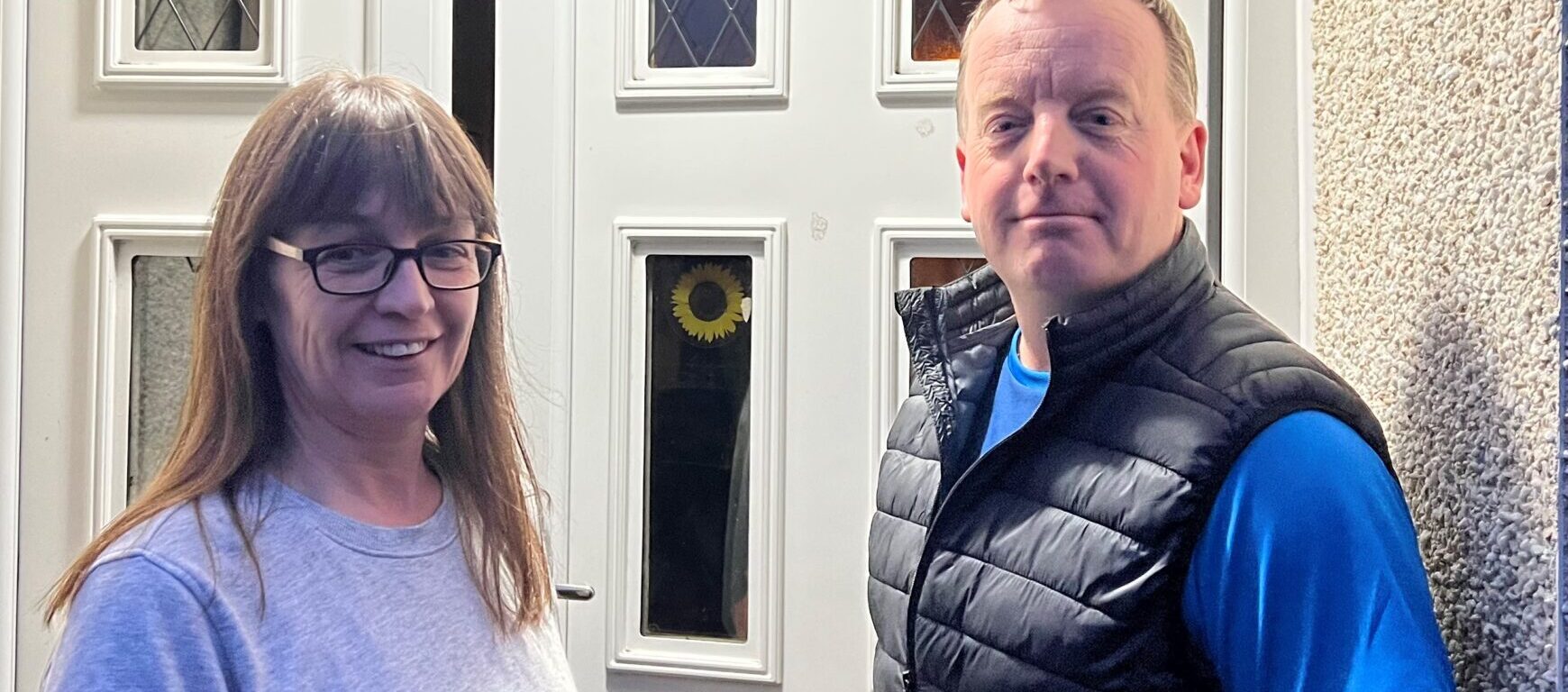 Woman and man standing outside front door
